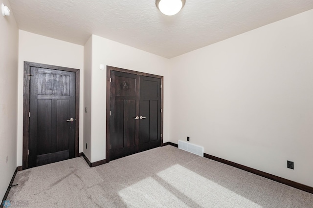 7373 14th St S, Fargo, ND 58104 - unfurnished bedroom featuring carpet flooring, a closet, and a textured ceiling