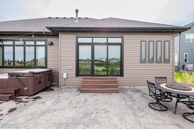 7373 14th St S, Fargo, ND 58104 - back of property featuring a hot tub, entry steps, a patio area, and roof with shingles