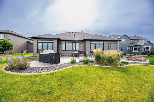 7373 14th St S, Fargo, ND 58104 - back of house with a patio, a lawn, and roof with shingles