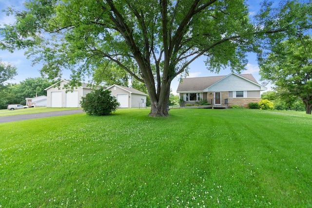 3568 Feldman Ave SE, Buffalo, MN 55313 - view of front facade with stone siding, a garage, a front yard, and an outbuilding