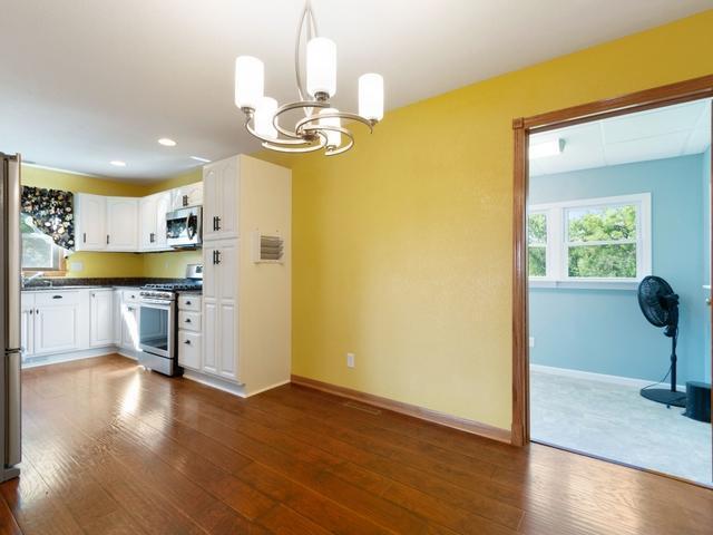 3568 Feldman Ave SE, Buffalo, MN 55313 - kitchen with stainless steel appliances, a chandelier, dark countertops, dark wood-type flooring, and recessed lighting