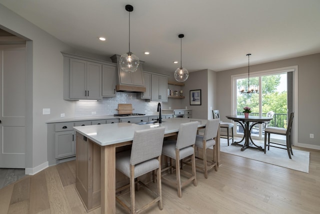 14714 146th Ave N, Dayton, MN 55327 - kitchen with gray cabinetry, premium range hood, light wood-type flooring, tasteful backsplash, and recessed lighting