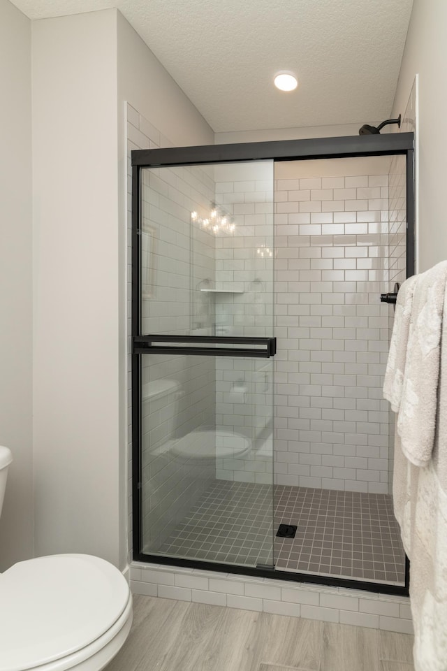 14714 146th Ave N, Dayton, MN 55327 - bathroom with wood finished floors, a shower stall, a textured ceiling, and recessed lighting