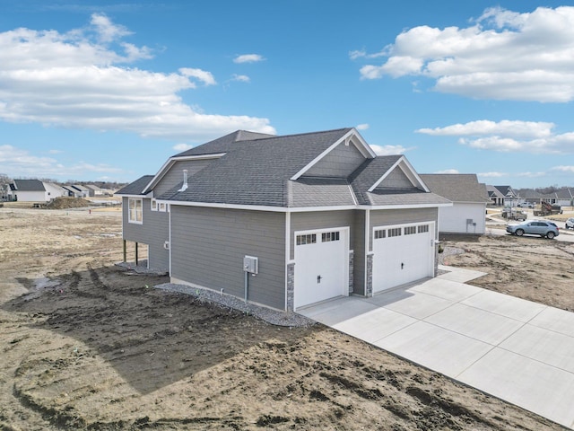14147 77th Ln NE, Otsego, MN 55330 - view of side of property featuring a garage, concrete driveway, a shingled roof, and a residential view