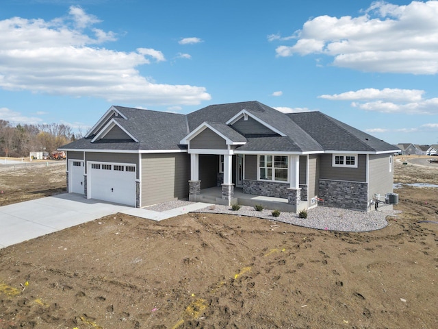14147 77th Ln NE, Otsego, MN 55330 - craftsman house featuring a garage, stone siding, driveway, a porch, and roof with shingles