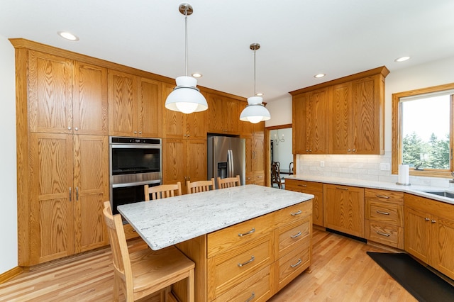 160 River Bluff Pl NW, Cascade Twp, MN 55901 - kitchen with appliances with stainless steel finishes, a breakfast bar area, light wood-style flooring, tasteful backsplash, and hanging light fixtures