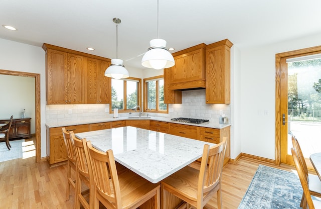 160 River Bluff Pl NW, Cascade Twp, MN 55901 - kitchen with stainless steel gas stovetop, recessed lighting, light wood-style floors, brown cabinets, and backsplash
