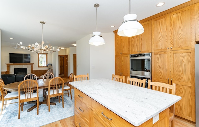 160 River Bluff Pl NW, Cascade Twp, MN 55901 - kitchen featuring light wood-type flooring, double oven, a kitchen island, hanging light fixtures, and recessed lighting