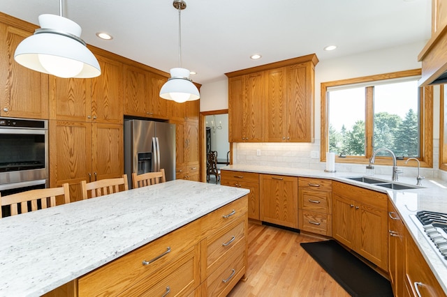 160 River Bluff Pl NW, Cascade Twp, MN 55901 - kitchen with stainless steel appliances, decorative light fixtures, light wood-type flooring, light stone countertops, and brown cabinets
