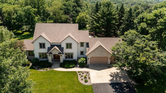 160 River Bluff Pl NW, Cascade Twp, MN 55901 - tudor home featuring stone siding, a garage, concrete driveway, a front yard, and roof with shingles