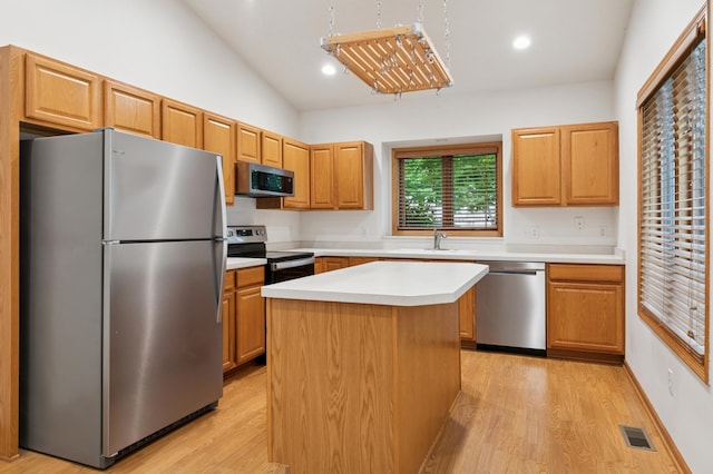 3406 Eagan Oaks Ct, Eagan, MN 55123 - kitchen with stainless steel appliances, light wood-style flooring, light countertops, lofted ceiling, and a kitchen island