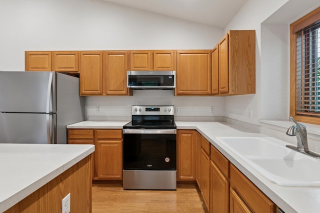 3406 Eagan Oaks Ct, Eagan, MN 55123 - kitchen featuring stainless steel appliances, vaulted ceiling, light wood finished floors, and light countertops
