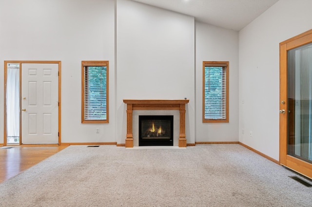 3406 Eagan Oaks Ct, Eagan, MN 55123 - unfurnished living room featuring carpet flooring, a fireplace with flush hearth, and a towering ceiling