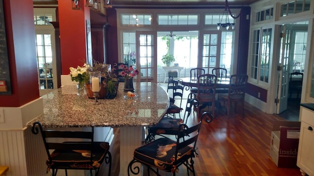 3307 Nokomis NE, Alexandria, MN 56308 - kitchen featuring dark wood finished floors, french doors, a kitchen breakfast bar, pendant lighting, and stone counters