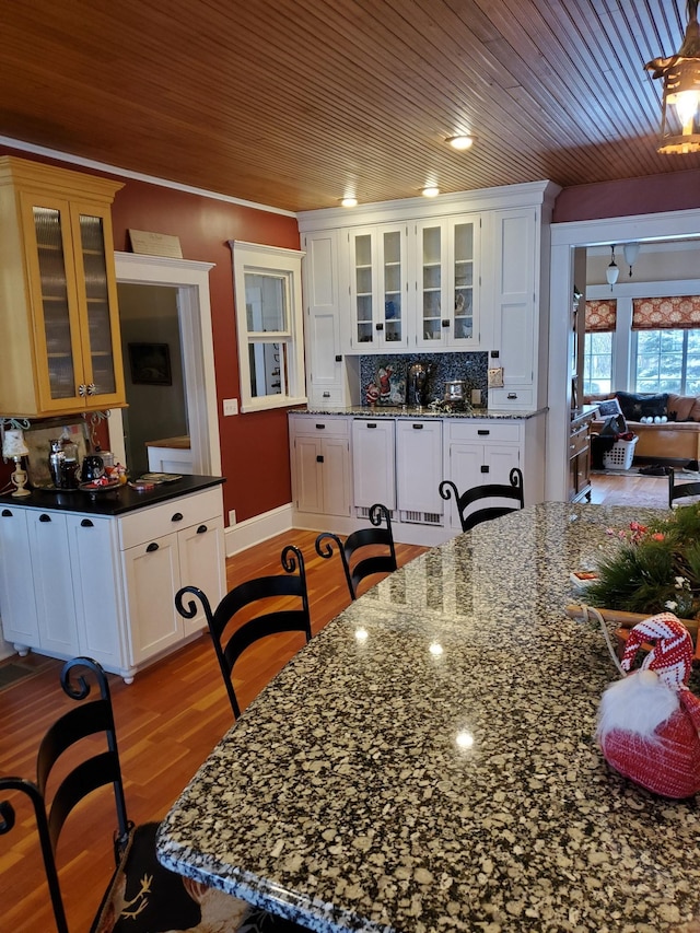 3307 Nokomis NE, Alexandria, MN 56308 - kitchen featuring decorative backsplash, wood ceiling, white cabinetry, light wood-style floors, and glass insert cabinets