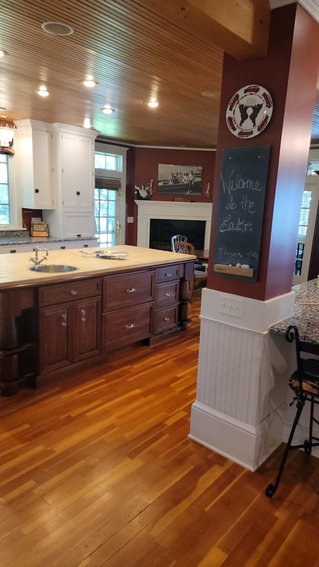 3307 Nokomis NE, Alexandria, MN 56308 - kitchen with light wood-style flooring, white cabinetry, light countertops, a fireplace, and wooden ceiling