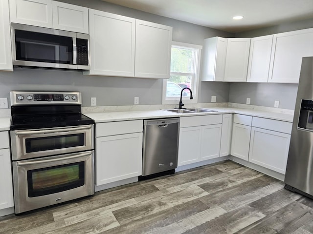 1204 10th St NE, Austin, MN 55912 - kitchen with stainless steel appliances, white cabinets, light wood finished floors, and recessed lighting