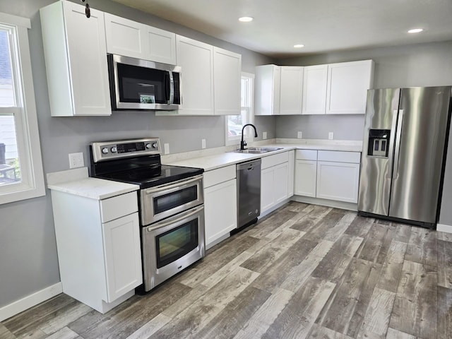 1204 10th St NE, Austin, MN 55912 - kitchen with stainless steel appliances, healthy amount of natural light, light wood-type flooring, light countertops, and recessed lighting