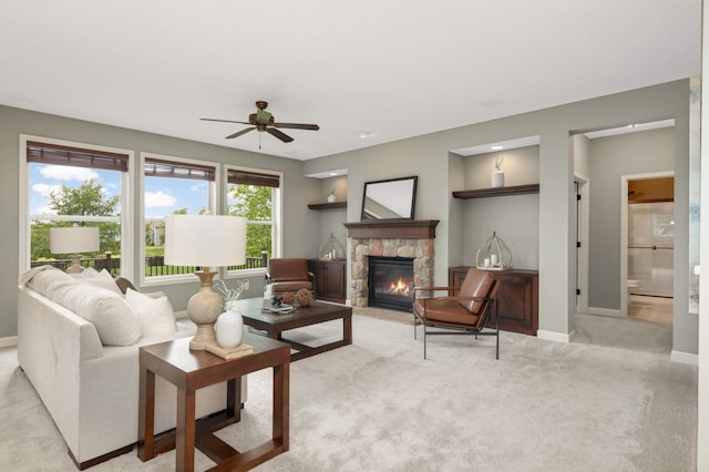 3153 Magnolia Dr, Medina, MN 55340 - living area with a stone fireplace, ceiling fan, and light carpet