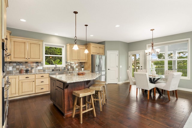 3153 Magnolia Dr, Medina, MN 55340 - kitchen featuring stainless steel appliances, a chandelier, light brown cabinets, decorative backsplash, and recessed lighting