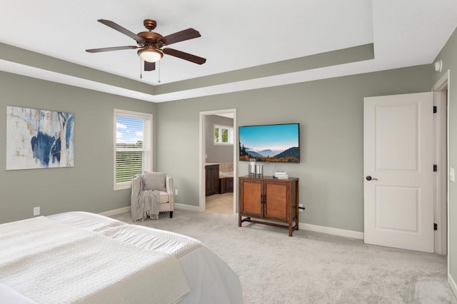 3153 Magnolia Dr, Medina, MN 55340 - bedroom featuring a tray ceiling, light carpet, connected bathroom, and a ceiling fan