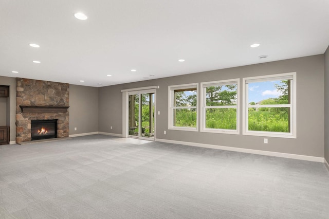3153 Magnolia Dr, Medina, MN 55340 - unfurnished living room featuring light colored carpet, recessed lighting, and a stone fireplace