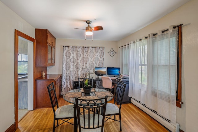 116 3rd Ave SE, Osseo, MN 55369 - dining area featuring baseboard heating, light wood-style flooring, and a ceiling fan