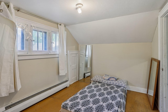116 3rd Ave SE, Osseo, MN 55369 - bedroom featuring a baseboard radiator, vaulted ceiling, and wood finished floors