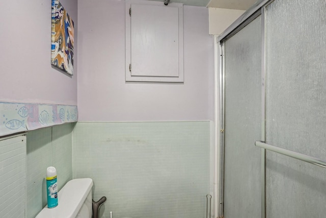 116 3rd Ave SE, Osseo, MN 55369 - bathroom featuring a stall shower, a wainscoted wall, and tile walls
