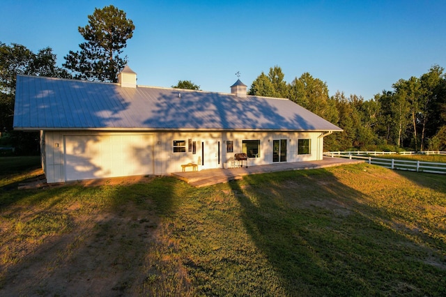 1650 Gunn Rd, Grand Rapids, MN 55744 - rear view of house with a metal roof, a chimney, driveway, and a patio area