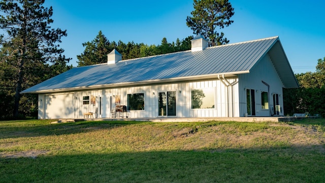 1650 Gunn Rd, Grand Rapids, MN 55744 - rear view of property with a chimney, a lawn, a metal roof, and board and batten siding