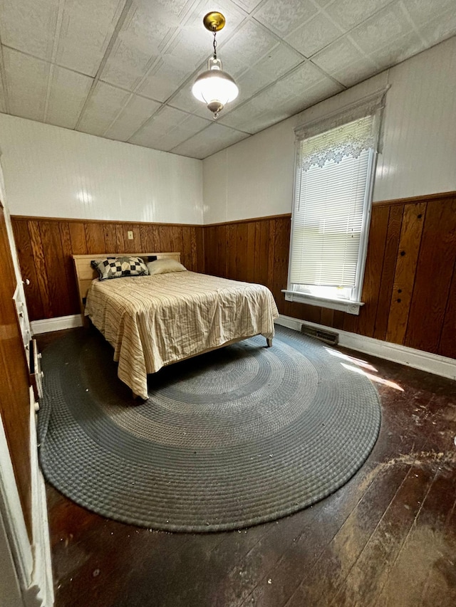 504 3rd Ave SE, Pipestone, MN 56164 - bedroom with wood walls, wainscoting, and hardwood / wood-style flooring