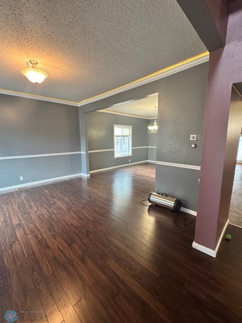 214 7th St, Hatton, ND 58240 - spare room featuring crown molding, a textured ceiling, hardwood / wood-style floors, and a chandelier