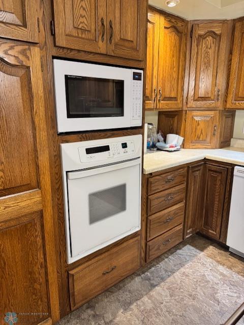 214 7th St, Hatton, ND 58240 - kitchen featuring white appliances, light countertops, and brown cabinets