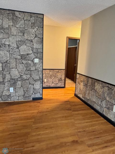 214 7th St, Hatton, ND 58240 - unfurnished room with wood finished floors, a textured ceiling, and wainscoting