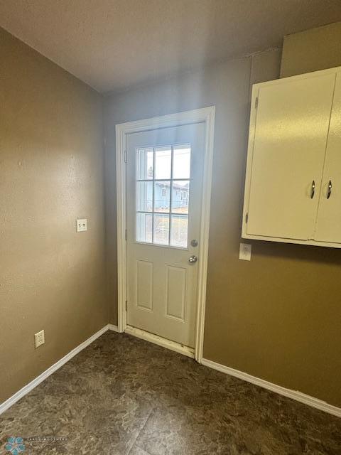 214 7th St, Hatton, ND 58240 - doorway with baseboards and dark carpet