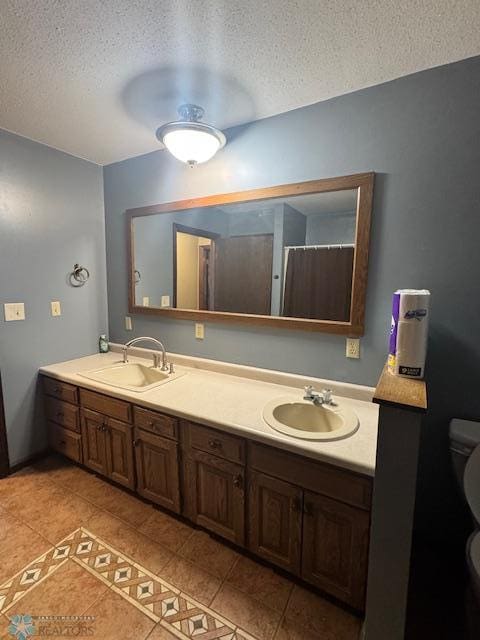 214 7th St, Hatton, ND 58240 - full bathroom with a textured ceiling, double vanity, and tile patterned floors