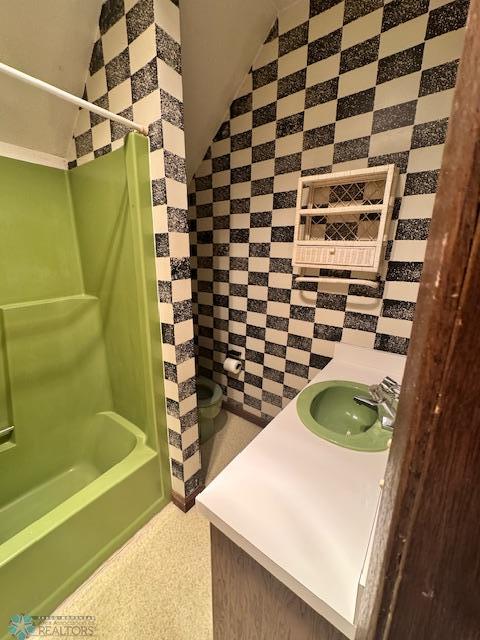 214 7th St, Hatton, ND 58240 - bathroom featuring tub / shower combination, vanity, and lofted ceiling