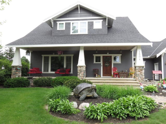 1504 4th St NE, Willmar, MN 56201 - rear view of house featuring a porch, roof with shingles, a yard, and stone siding