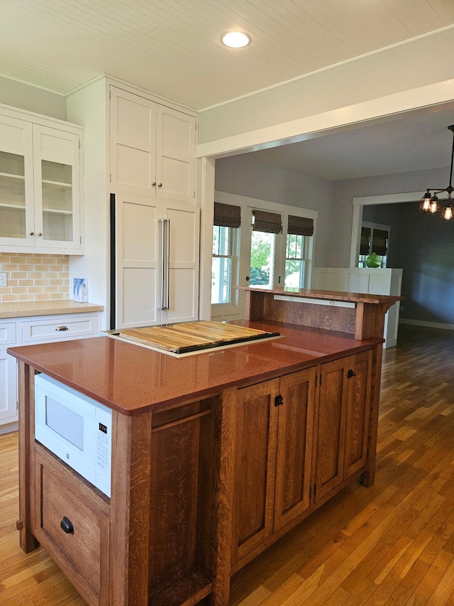 1504 4th St NE, Willmar, MN 56201 - kitchen featuring white microwave, hardwood / wood-style flooring, a center island, recessed lighting, and white cabinetry