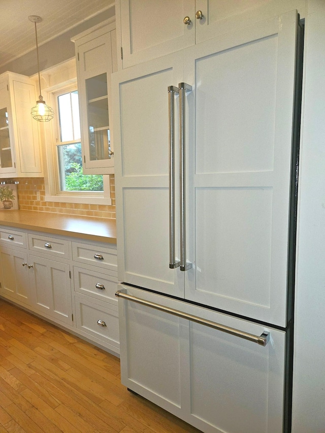 1504 4th St NE, Willmar, MN 56201 - kitchen featuring light countertops, glass insert cabinets, white cabinets, and pendant lighting