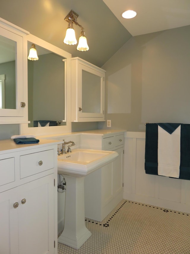 1504 4th St NE, Willmar, MN 56201 - bathroom with vaulted ceiling, tile patterned flooring, a decorative wall, and a wainscoted wall