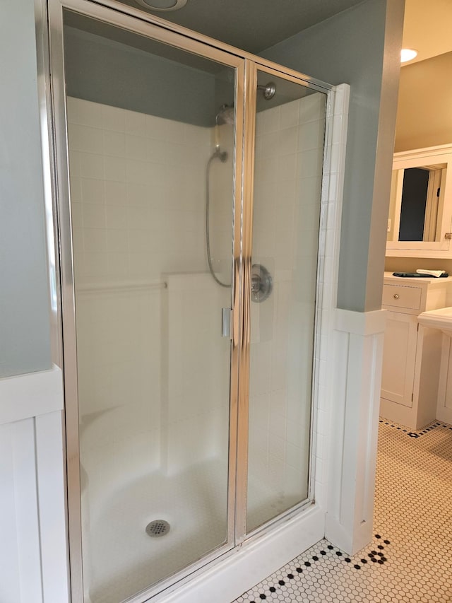 1504 4th St NE, Willmar, MN 56201 - full bathroom with a stall shower, vanity, tile patterned floors, and a wainscoted wall