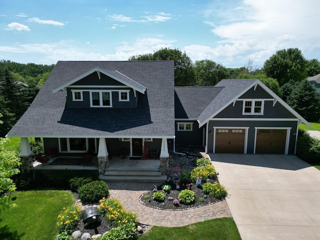 1504 4th St NE, Willmar, MN 56201 - craftsman inspired home with covered porch, concrete driveway, a shingled roof, a garage, and a front lawn