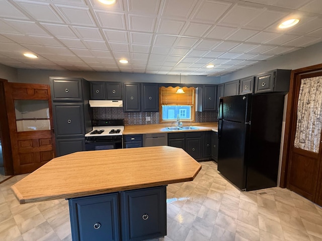 681 8th St, Walnut Grove, MN 56180 - kitchen with freestanding refrigerator, gas range oven, under cabinet range hood, light countertops, and a center island