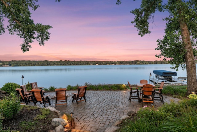 12795 Ozark Trl N, May Twp, MN 55082 - patio terrace at dusk with a patio area, a water view, boat lift, and a boat dock