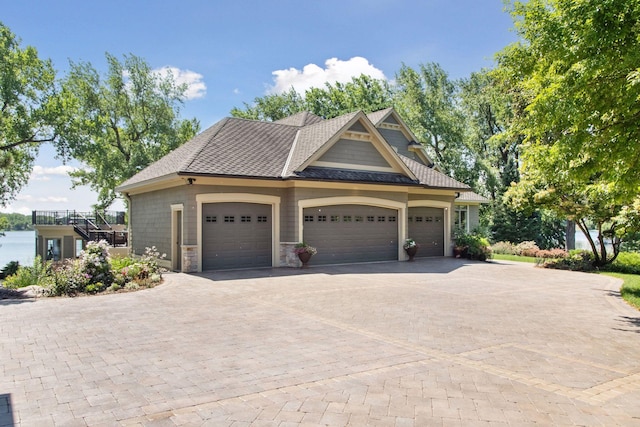 12795 Ozark Trl N, May Twp, MN 55082 - view of front facade with decorative driveway, a garage, and stone siding