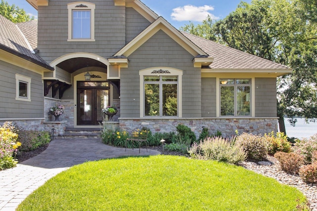 12795 Ozark Trl N, May Twp, MN 55082 - craftsman-style home with stone siding, a front yard, french doors, and a shingled roof