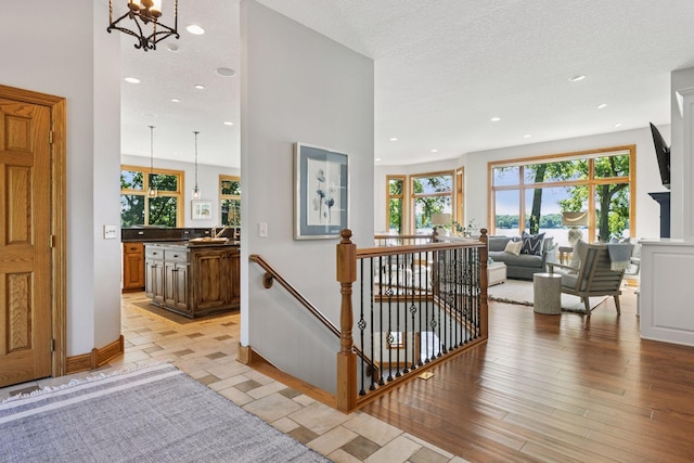 12795 Ozark Trl N, May Twp, MN 55082 - hallway with an upstairs landing, a chandelier, recessed lighting, and light wood-style flooring