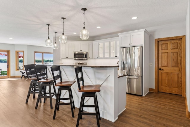 12795 Ozark Trl N, May Twp, MN 55082 - kitchen featuring stainless steel appliances, a center island, dark wood-type flooring, white cabinetry, and recessed lighting